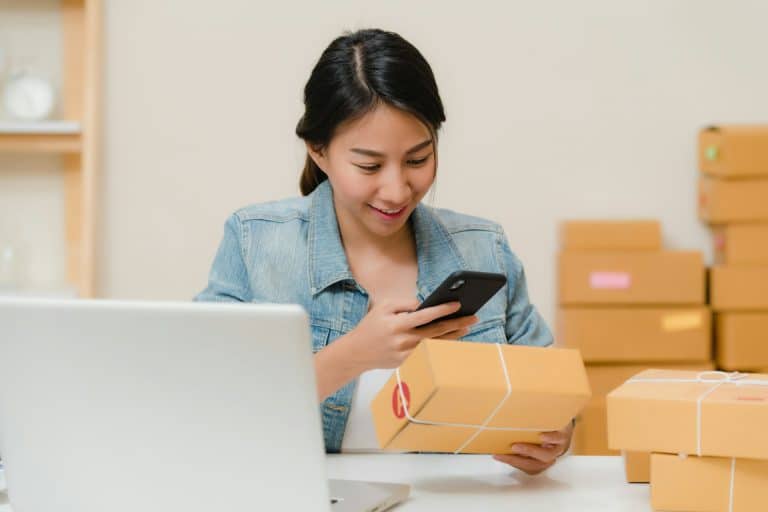 Femme vérifiant un colis commandé en ligne avec son téléphone